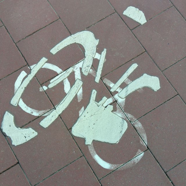 Two overlapping bike icons on the pavement.